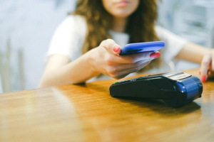 An image of a person using a smartphone to make an electronic payment